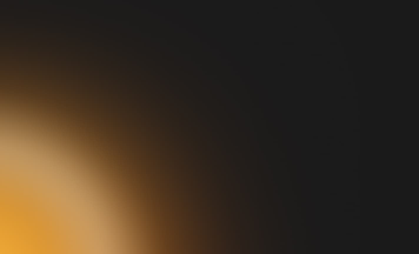 Abstraktní pozadí s přechodem teplých zlatavých tónů do černé barvy.